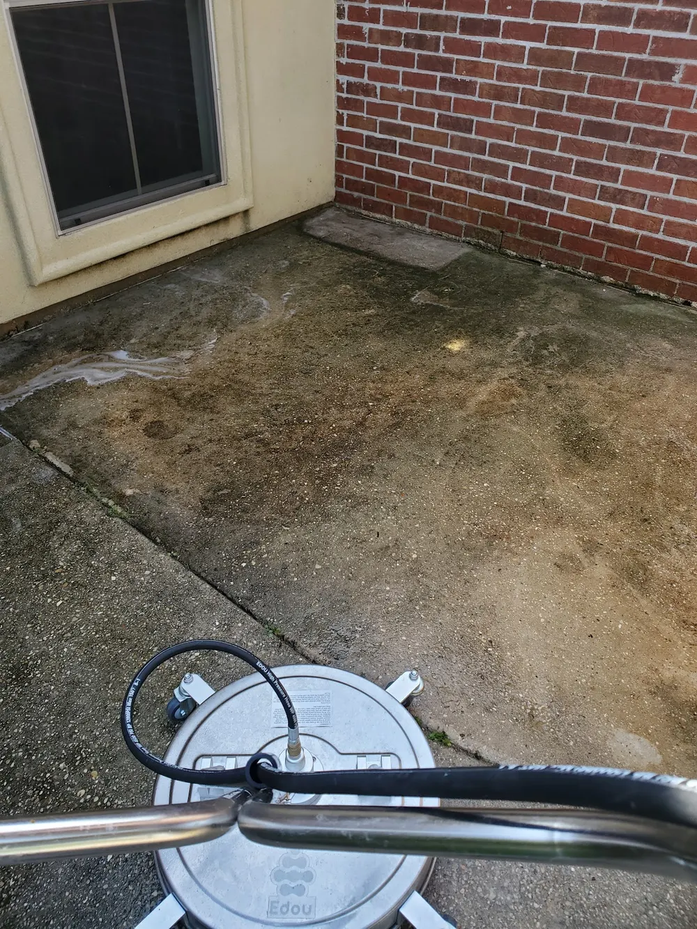 Surface-cleaner equipment mid-job on a concrete patio